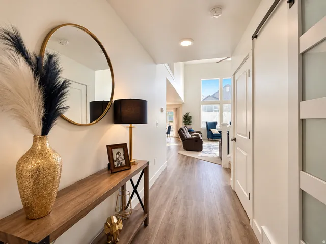 Wood-finish flooring, recessed lighting, white interior doors, and a decorative sliding barn door
