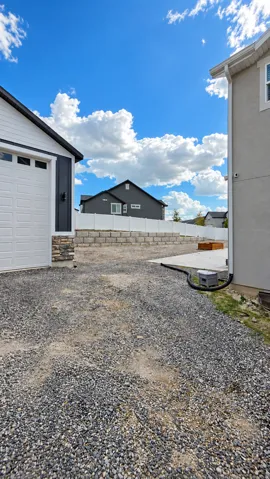 Gravel driveway providing access to a two-car garage with a white sectional door