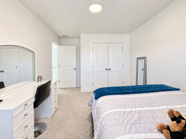 Plush carpet flooring, white painted walls, and a flush mount ceiling light