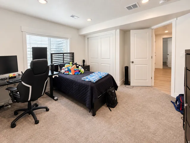 Recessed lighting, light-toned carpeting, white two-panel interior door, and a white two-panel closet door