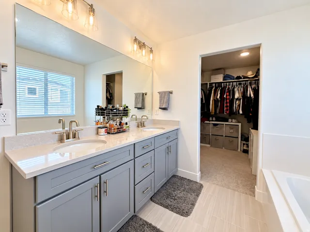 Dual vanity featuring light gray cabinetry, brushed nickel hardware, and light-toned countertops