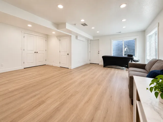 Spacious room featuring wood-finish flooring, recessed lighting, and white trim throughout