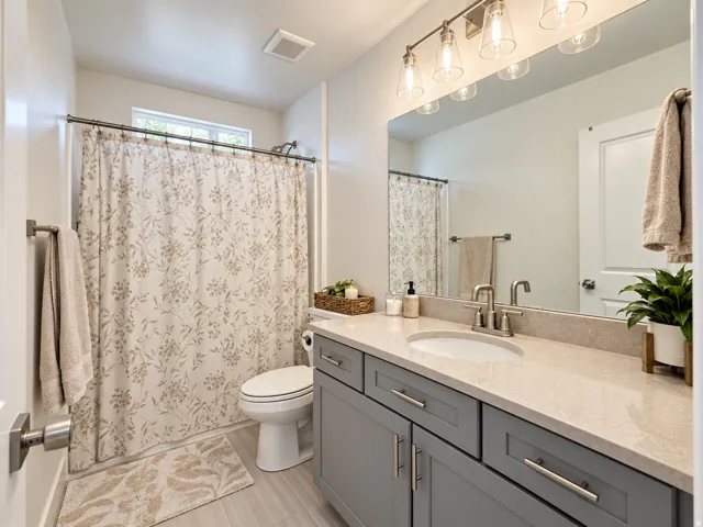 Bathroom featuring a single vanity with gray cabinetry, a light-colored countertop, and a rectangular undermount sink