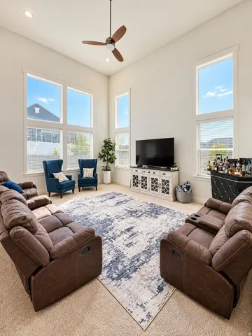 Vaulted ceilings with recessed lighting, ceiling fan, and large windows
