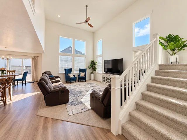 Open-concept living space featuring high ceilings, wood-finish flooring, and large windows
