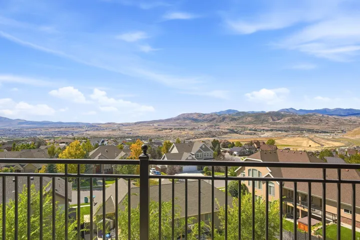 Black wrought iron railing with a mountain and city backdrop