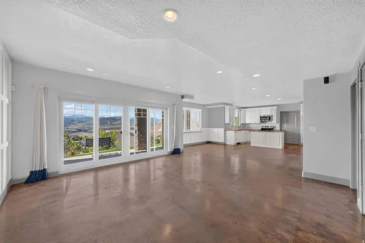 Open-concept living space featuring wood-finish flooring, recessed lighting, and expansive sliding glass doors