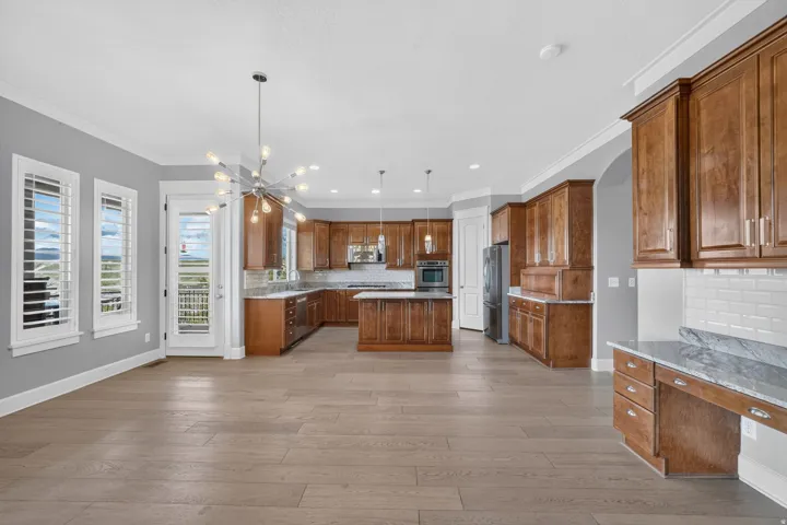 Expansive kitchen with wood-finish cabinetry, stainless steel appliances, and a central island