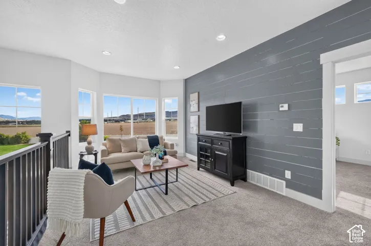Great room with extensive windows, recessed lighting, and a textured accent wall