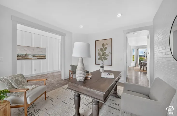 Recessed lighting, wood-finish flooring, white walls, and a white paneled accent wall