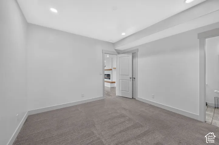 Recessed lighting, light gray wall tones, and gray carpeting