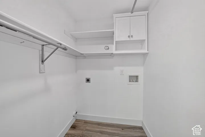 White cabinetry, integrated shelving, and wood-finish flooring