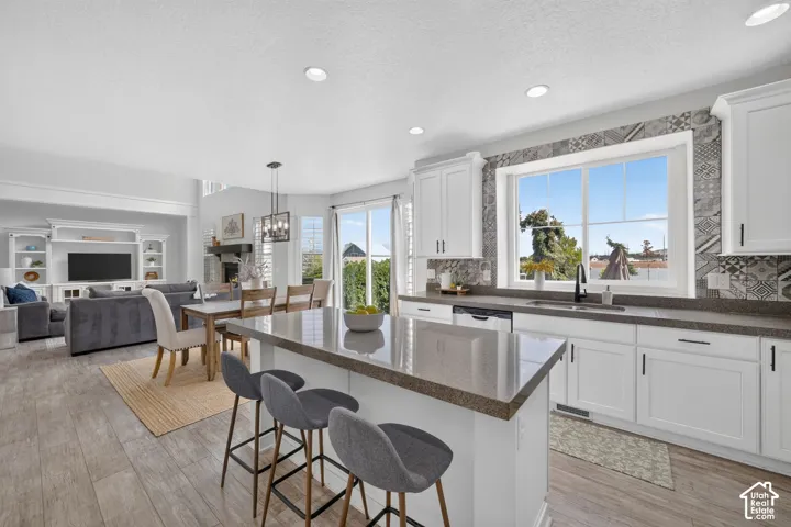 Kitchen featuring white shaker cabinetry, dark countertops, and a patterned tile backsplash