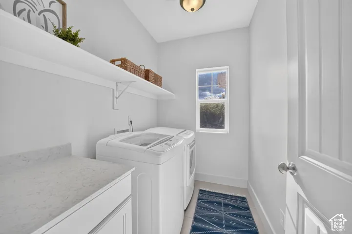 Functional laundry area featuring built-in cabinetry, a countertop, an upper shelf, a window, and a paneled door