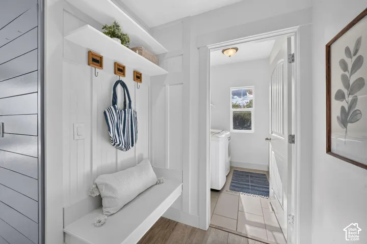 Built-in bench seating with storage hooks, two display shelves, and wood-finish flooring