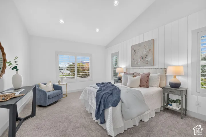 White shiplap accent wall with a vaulted ceiling
