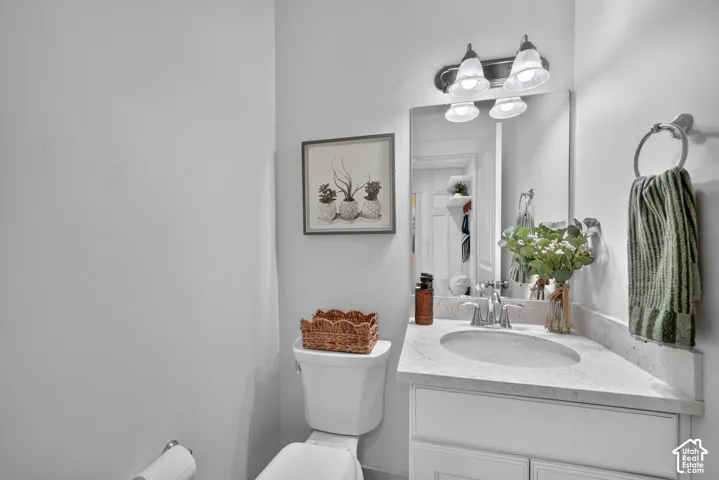 Corner vanity with a built-in oval sink, white cabinetry, and a light-toned countertop
