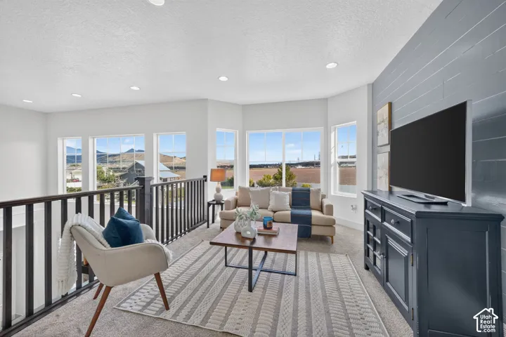 Open loft space featuring recessed lighting, extensive window panels, and a shiplap accent wall