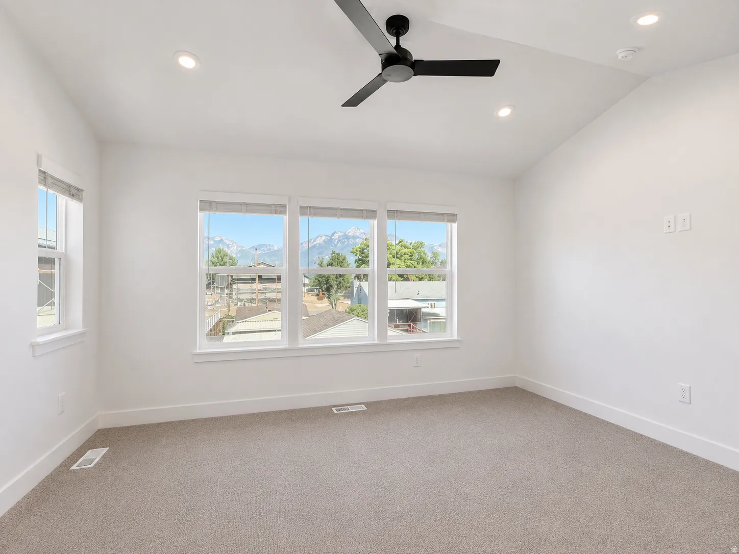 Vaulted ceiling with recessed lighting and a ceiling fan