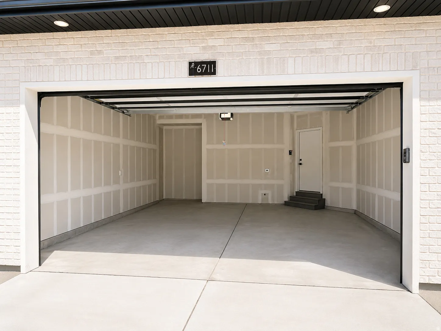 Attached two-car garage with a finished concrete floor and white brick exterior
