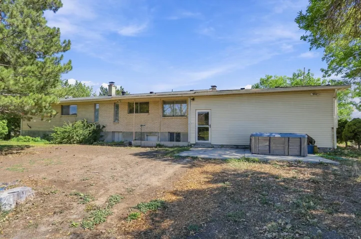 Exterior featuring brick and horizontal siding, multiple windows, and a paved patio area