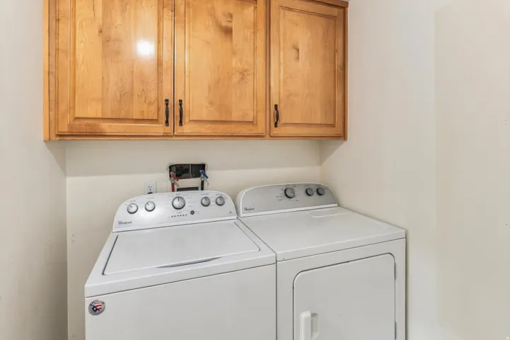 Upper cabinetry with wood-finish doors and dark hardware