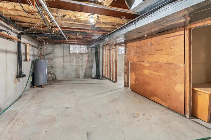 Concrete flooring, exposed joists, built-in shelving, water heater, utility connections