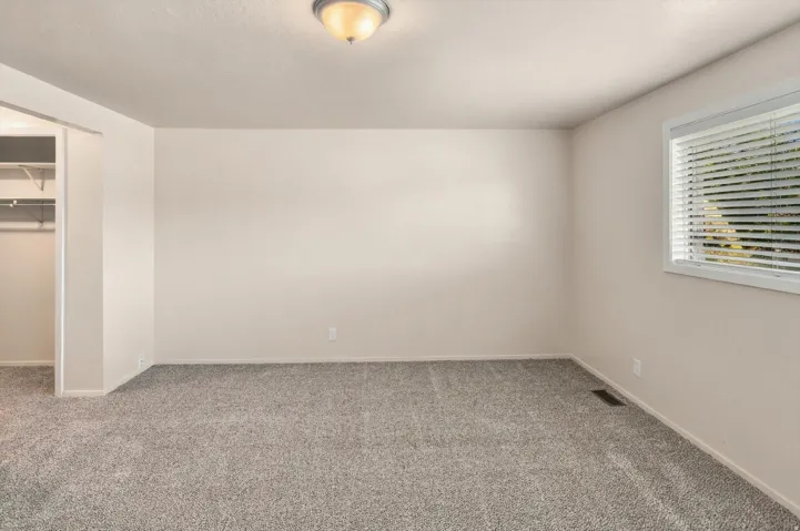 Neutral-toned walls complement the carpeted flooring