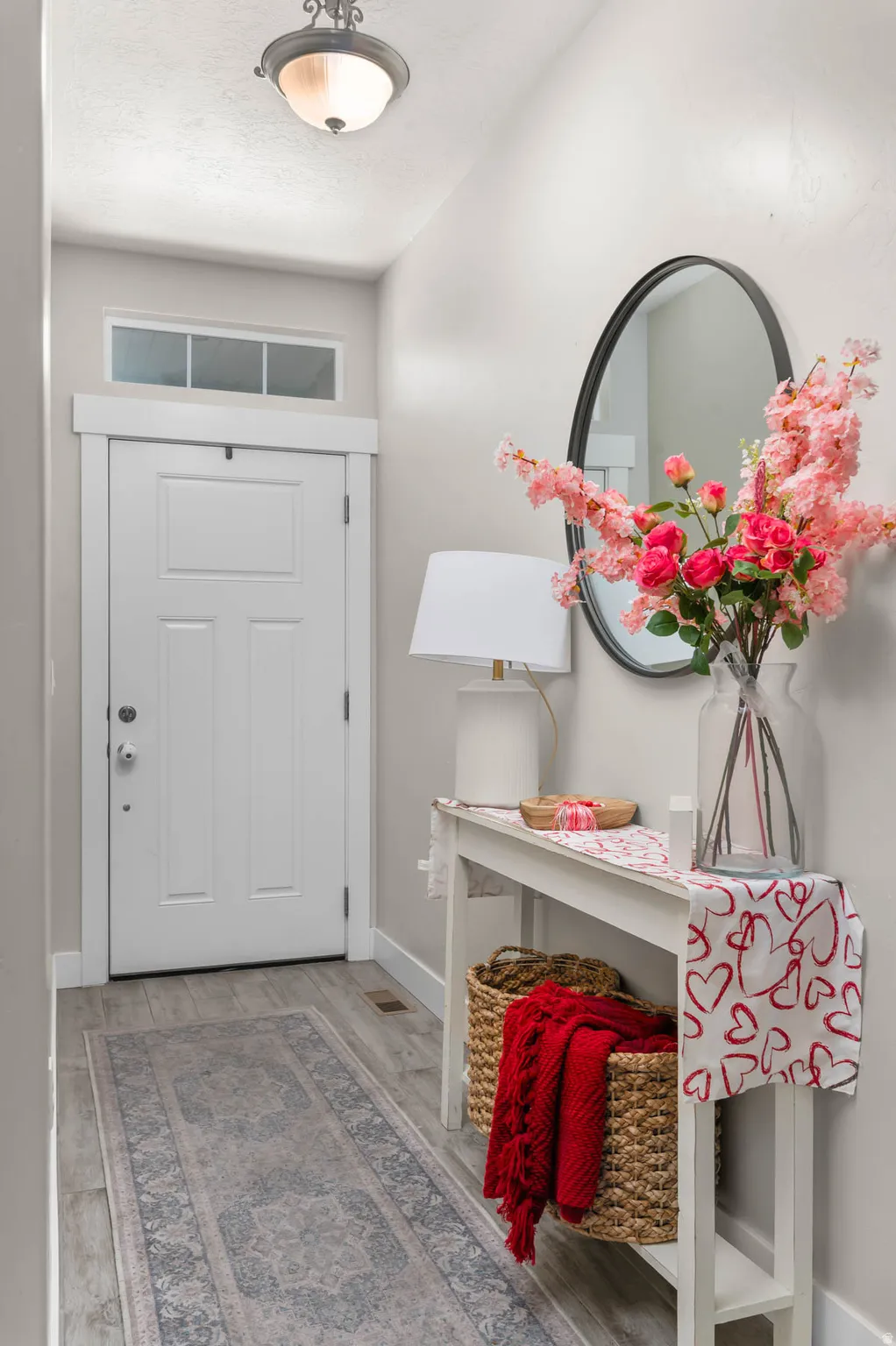 Recessed entryway featuring wood-finish flooring and a transom window above the entry door