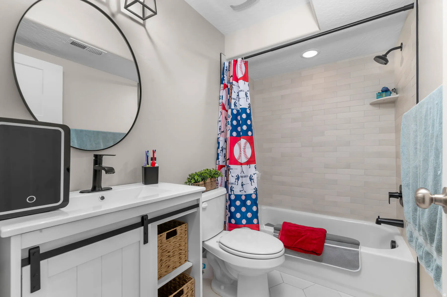 White vanity with black barn door hardware, white rectangular sink, and matte black faucet