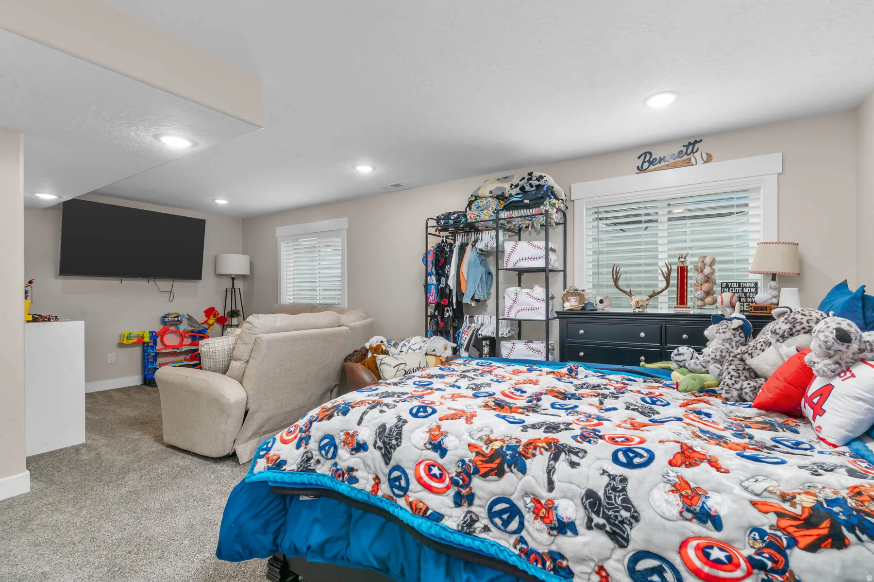 Recessed lighting and a wall-mounted television are featured, with a window offering natural light