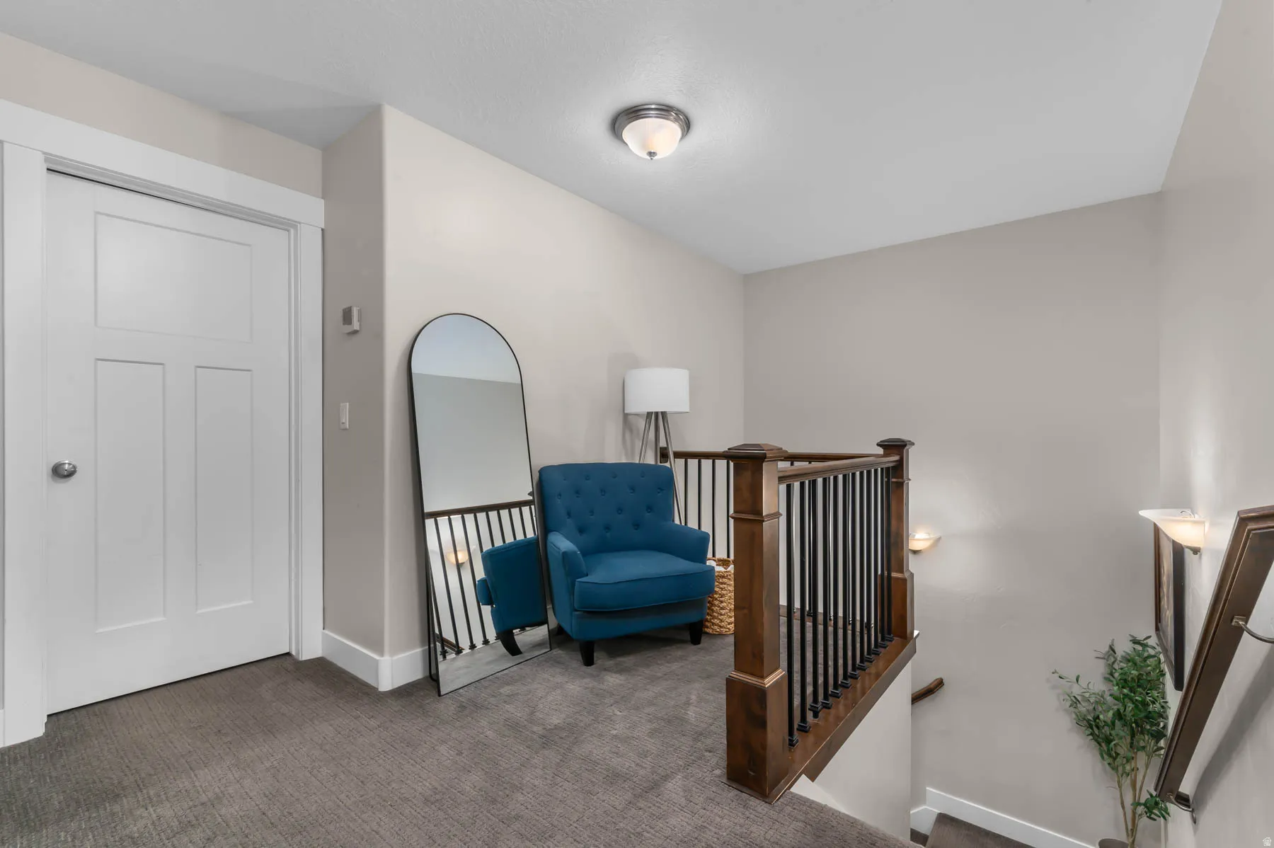 Hardwood newel posts, wrought iron balusters, and wall-mounted sconces