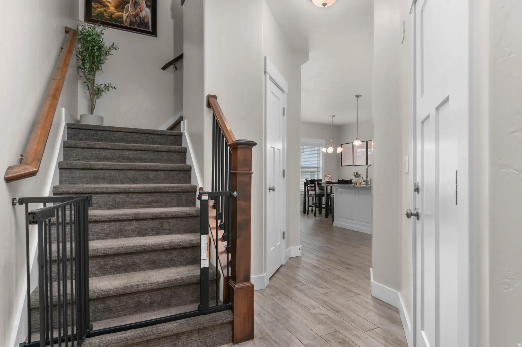 Wood-finish flooring, recessed lighting, white interior doors, and carpeted stairs with a wood railing