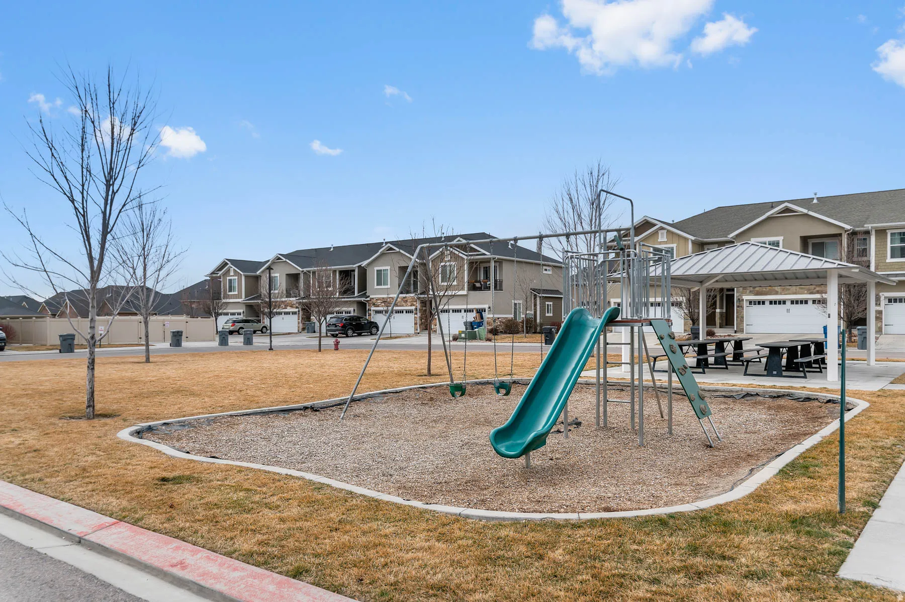 Community green space featuring a playground with a slide and swings