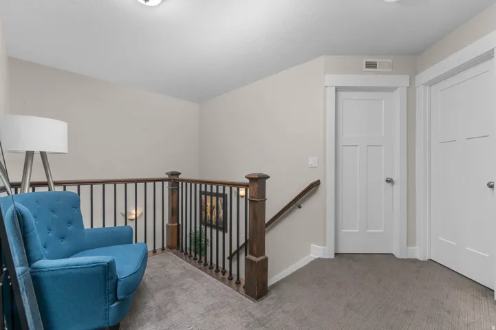 Hardwood newel posts, wrought iron balusters, wood handrail, paneled interior doors, and neutral carpeting