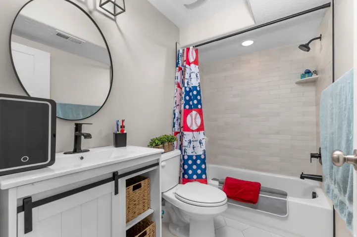 White vanity with black barn door hardware, white rectangular sink, and matte black faucet
