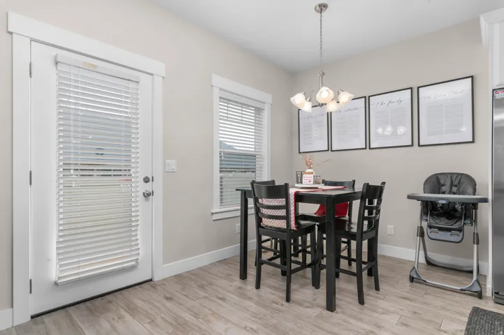 Wood-finish flooring, white trim, recessed lighting, double-pane window, and a glass-panel door