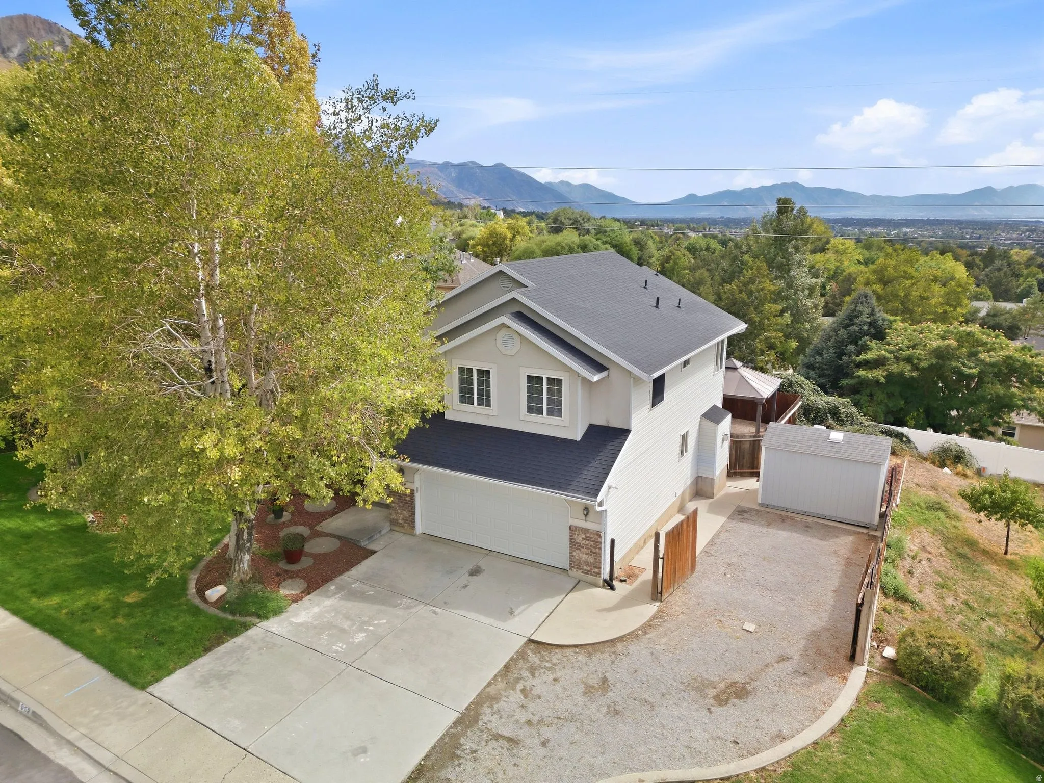 Aerial view of the front of the home showcasing the RV or boat parking with the mountain and lake views, as well as the detached shed