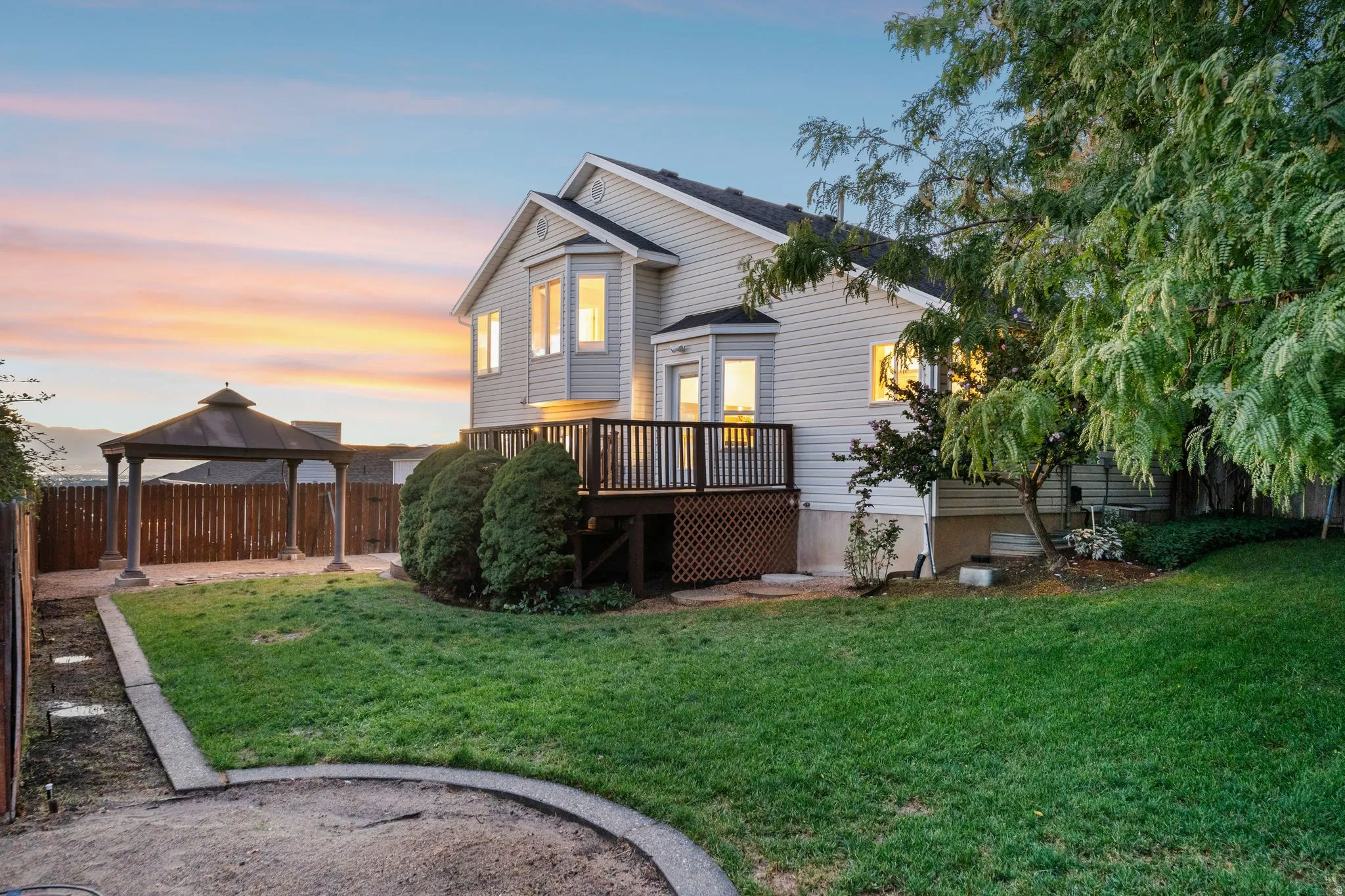 Back view of the home and yard at twilight