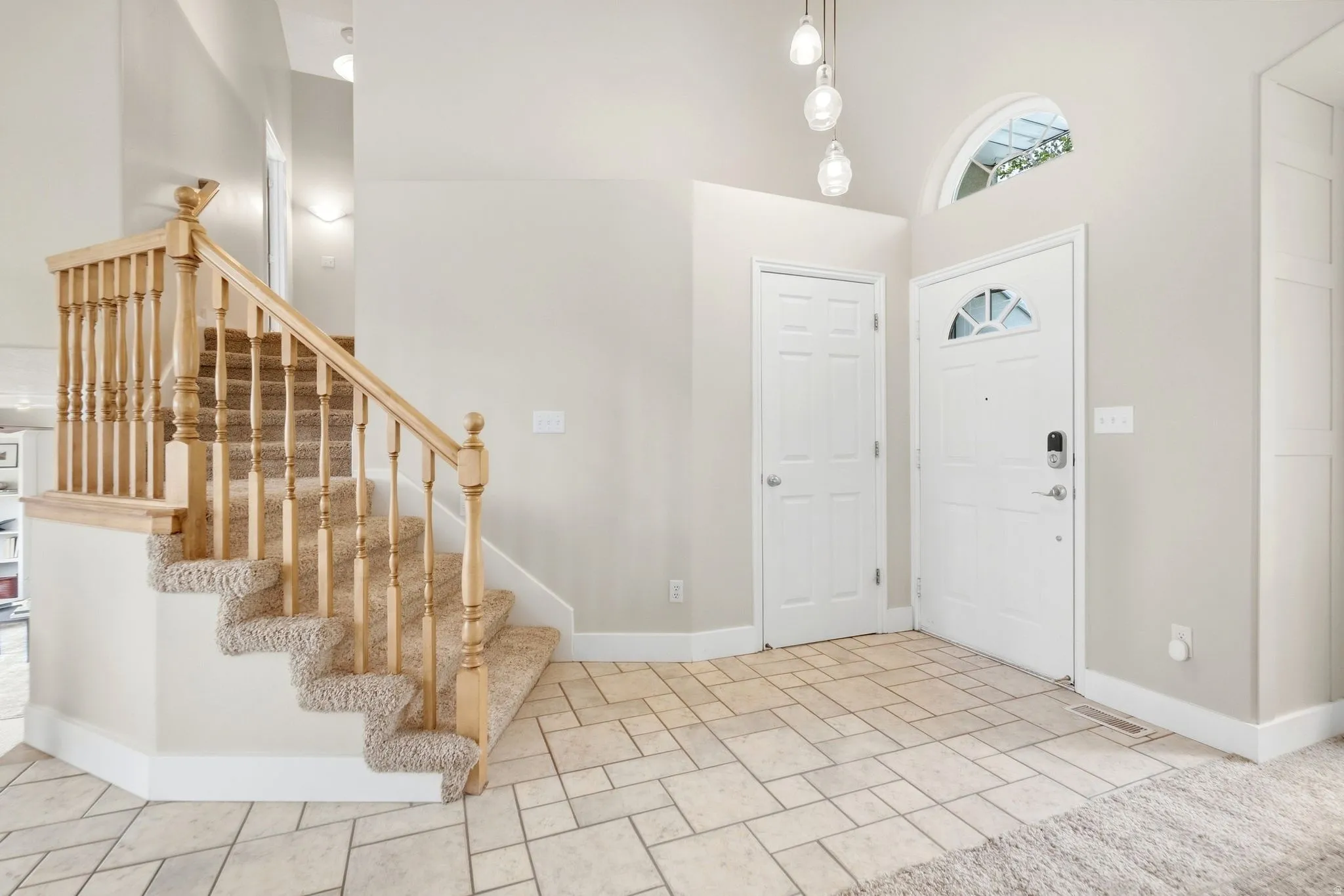 Front entry, coat closet, and stairs leading to upper levek