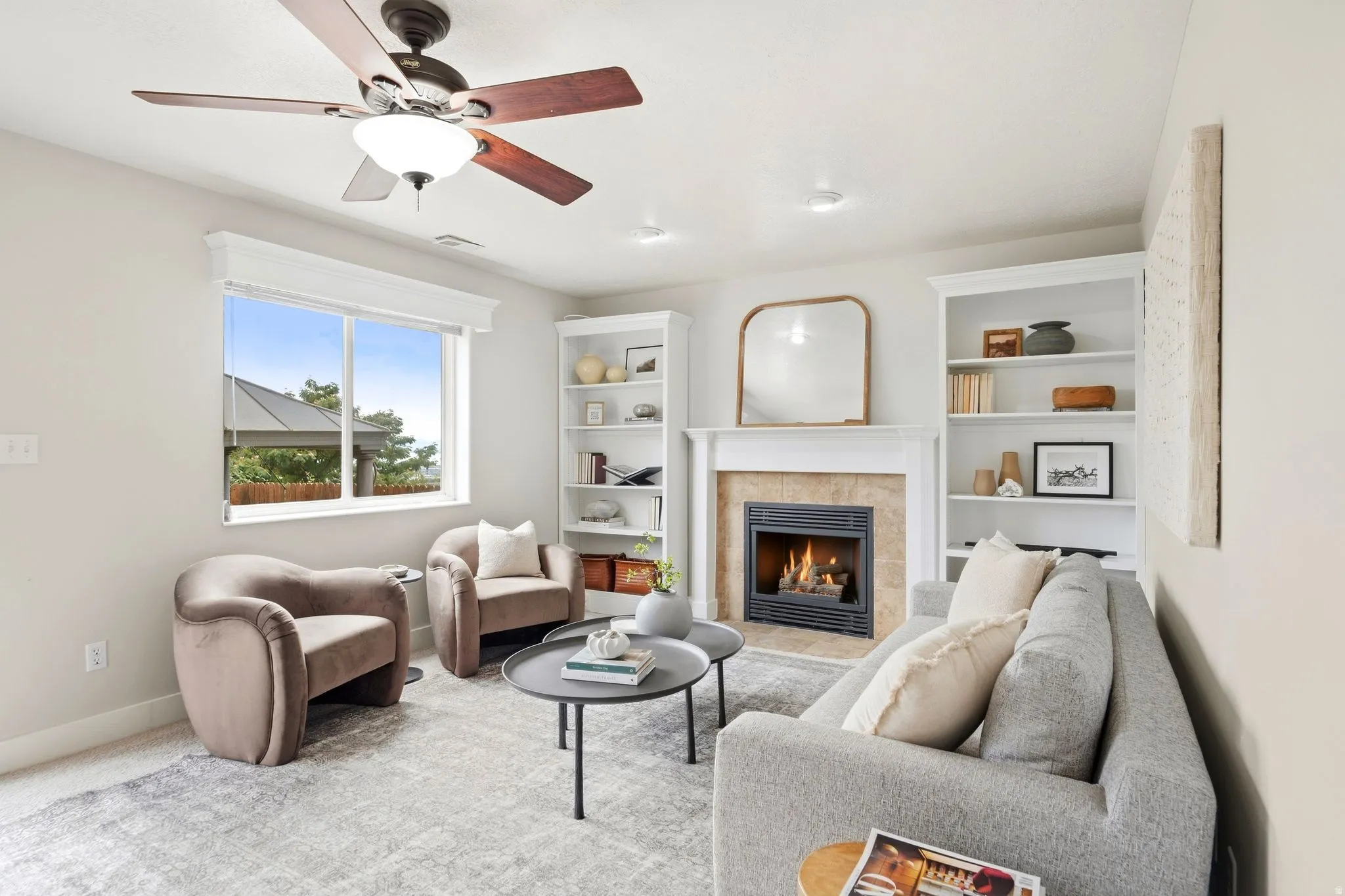 Lower living room off of the garage entrance with a gas fireplace, ample natural light, access to the back deck, and built-in shelving