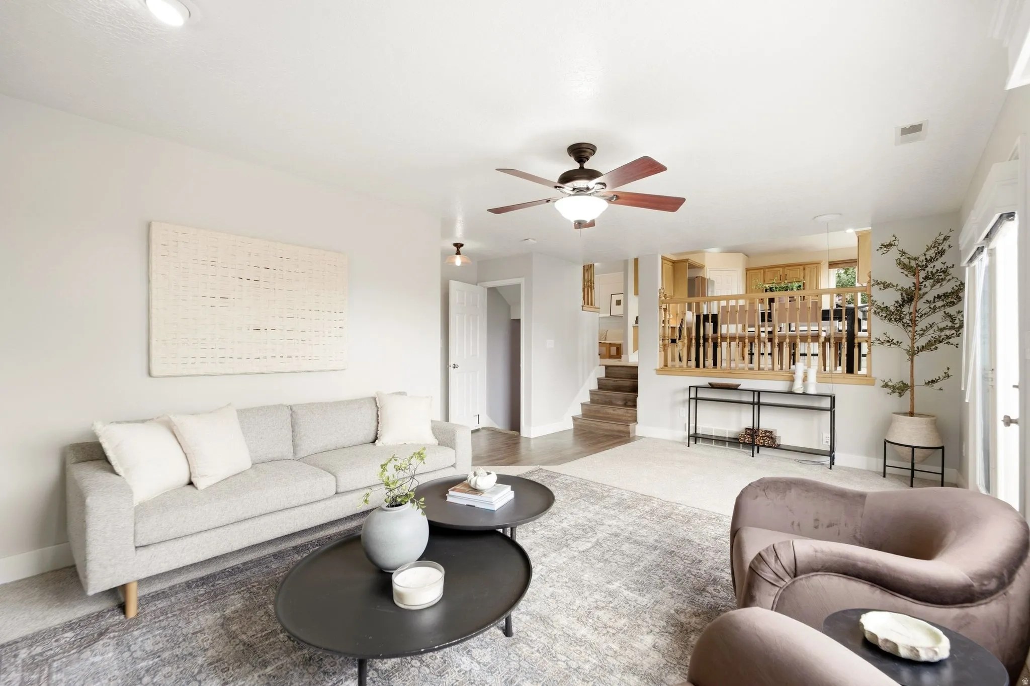 Lower living room with a view of the door that accesses the basement, as well as looking back up into the dining room and kitchen area