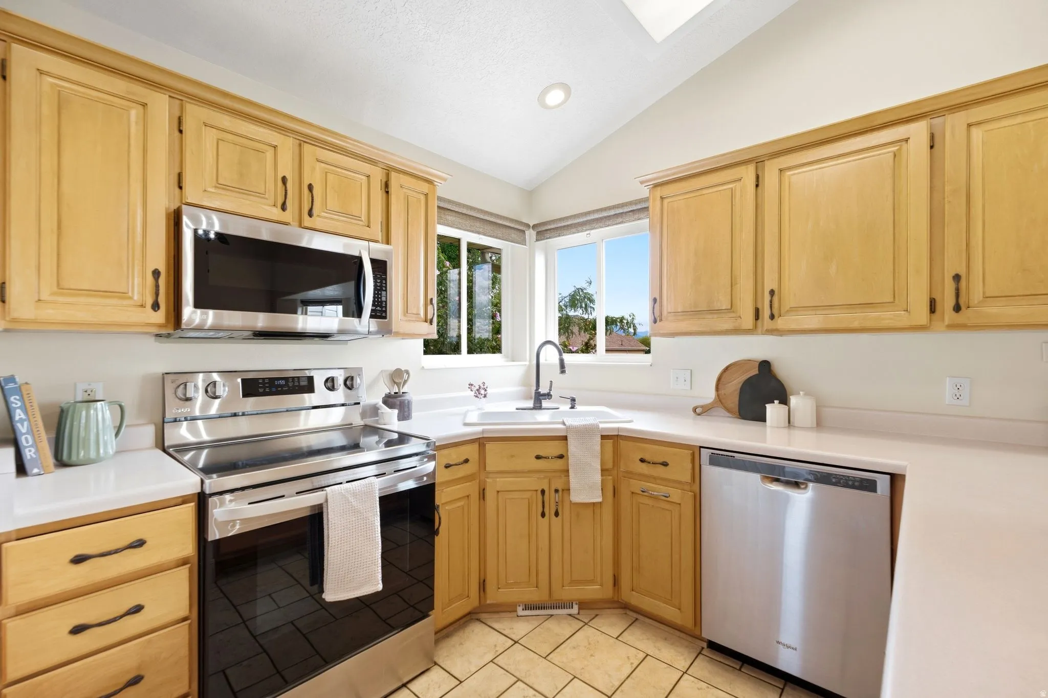 Kitchen with stainless steel appliances and a corner window over the sink. Ample counter space