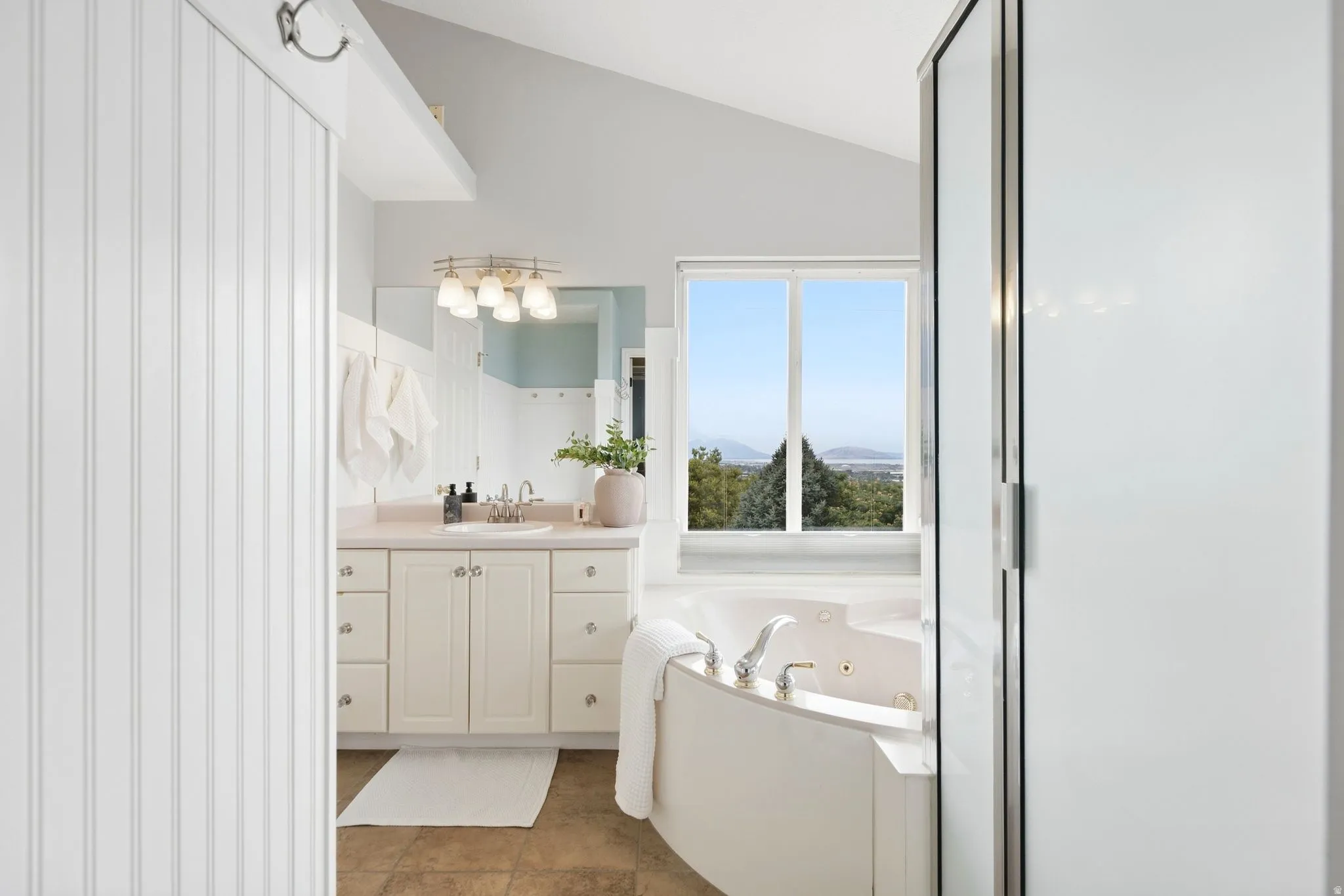 Large ensuite bathroom with separate soaking tub and shower and vaulted ceilings.