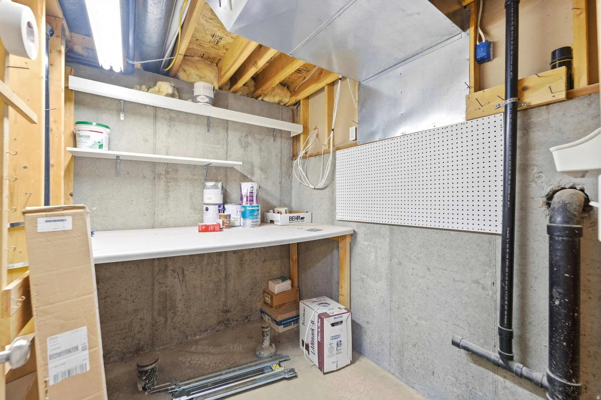 Unfinished space currently used as a small workroom. However, it is plumbed for an additional bathroom, so you could add a fourth bathroom that would be off the basement bedroom and living room