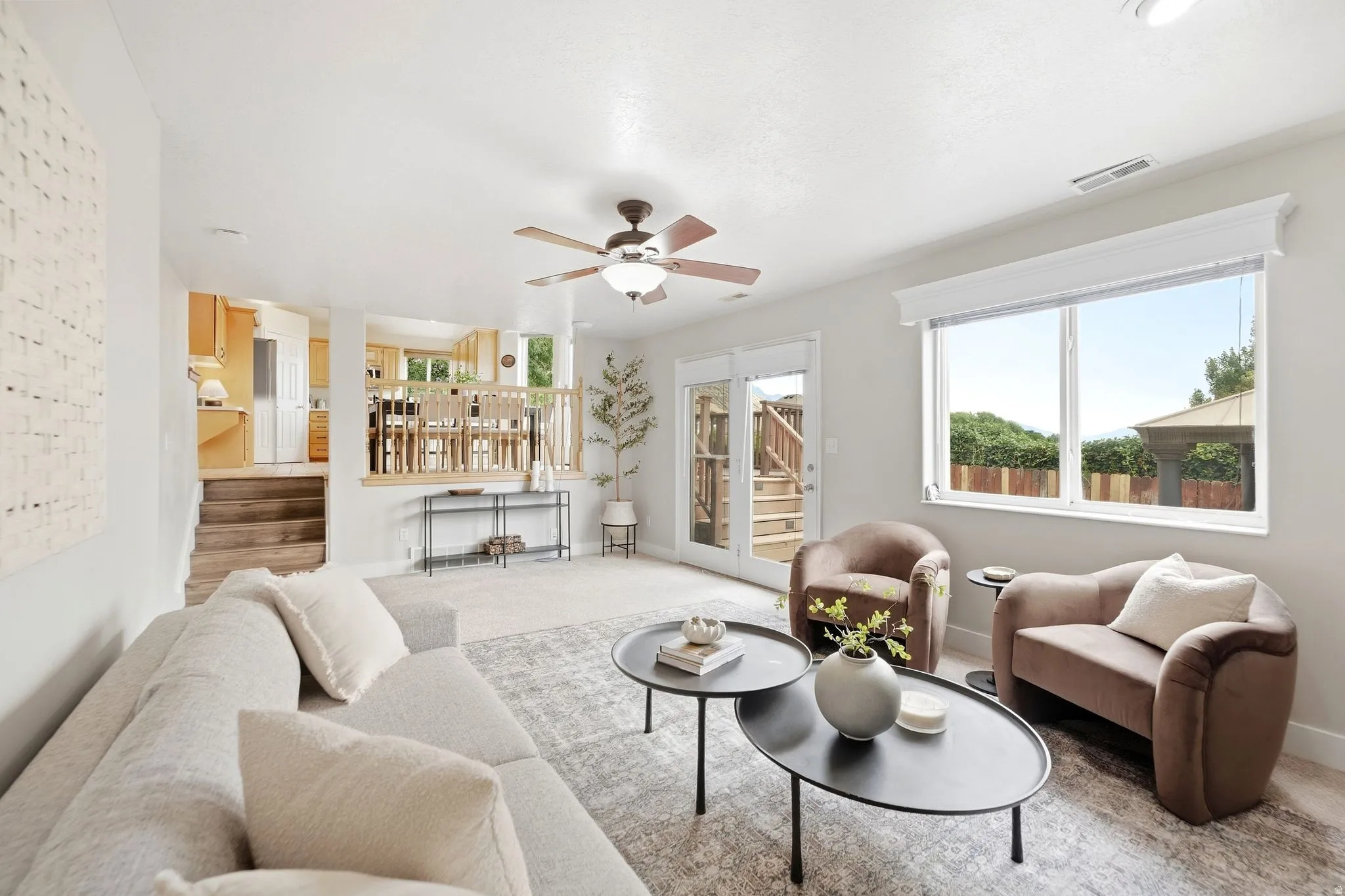 Lower living room with a view of the door that accesses the back deck, as well as looking back up into the dining room and kitchen area