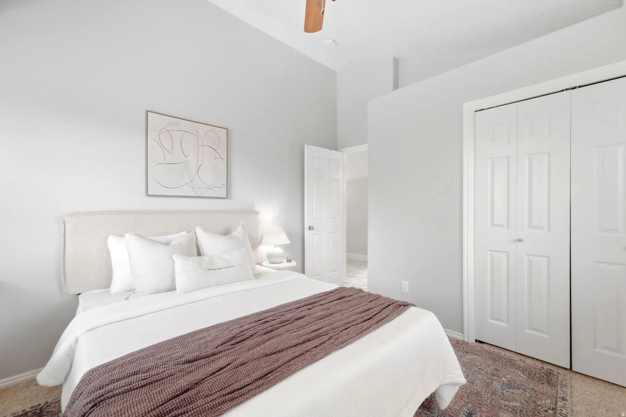 Second upstairs bedroom, across the hall from the primary bedroom, with vaulted ceilings and a cozy reading nook window seat.