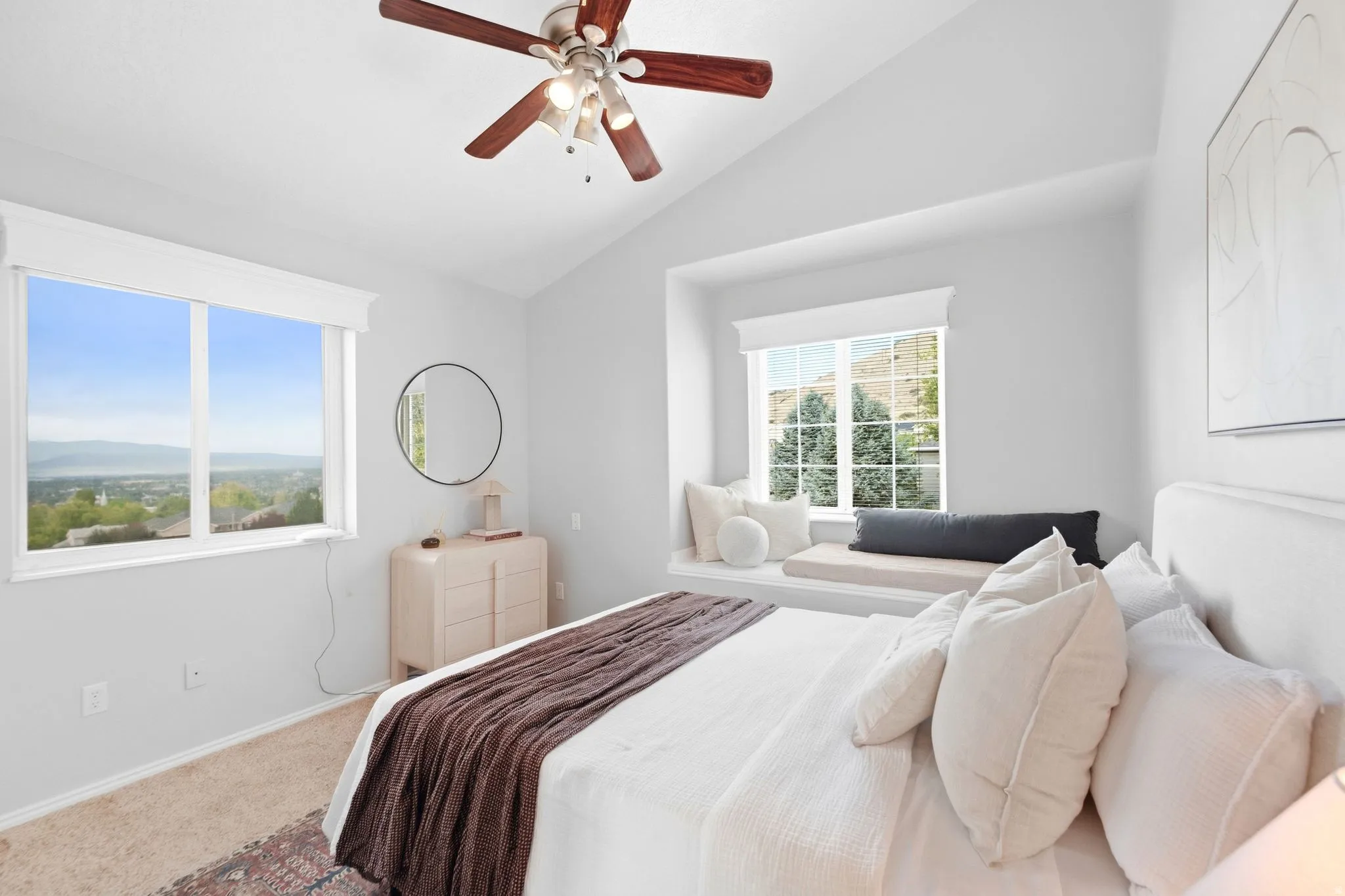 Second upstairs bedroom, across the hall from the primary bedroom, with vaulted ceilings and a cozy reading nook window seat. Ample natural light and incredible mountain and lake views.