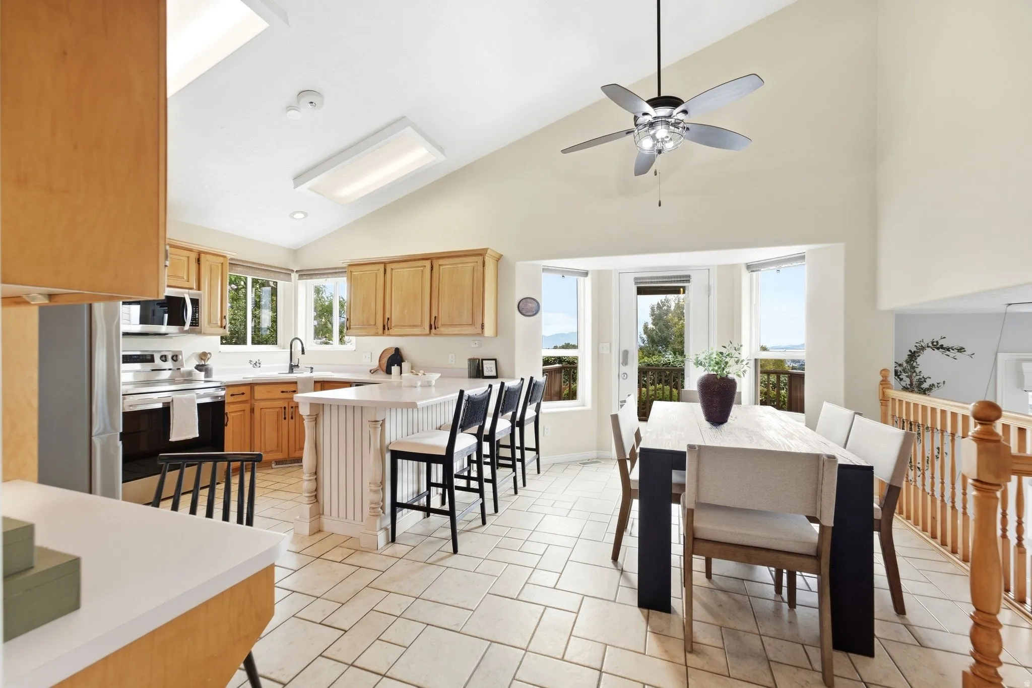 View of the dining room and kitchen with vaulted ceilings , and a view of the back door leading out to the deck