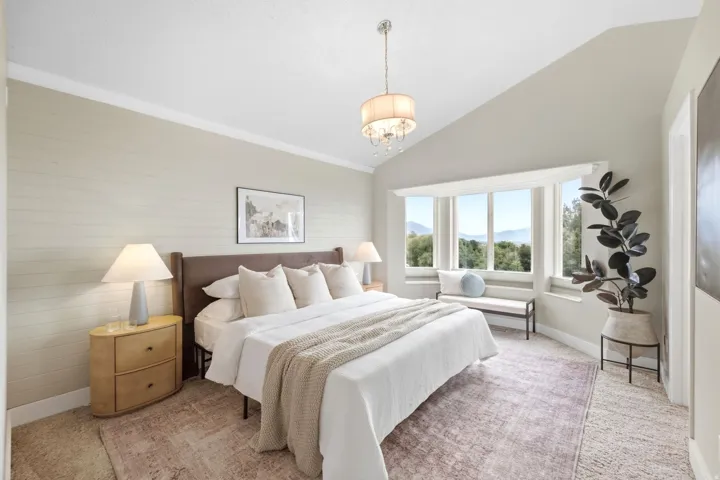 Primary bedroom with vaulted ceilings, full natural light, and spectacular mountain, lake, and valley views